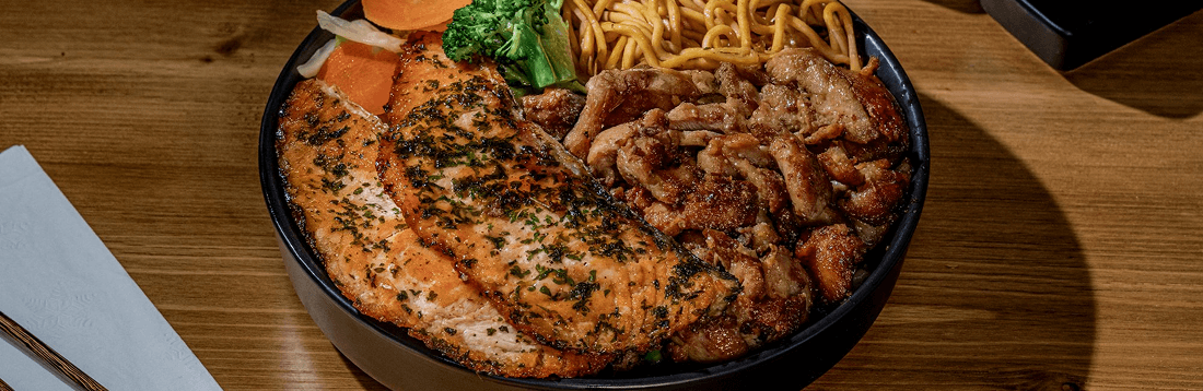 Fresh hibachi bowl with grilled proteins, noodles, and vegetables from Flame Japanese Hibachi